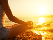 Een Yogahouding op een rots aan het water.